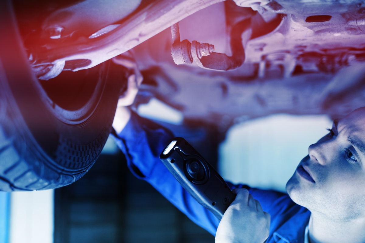 osoba proverava gume na automobilu