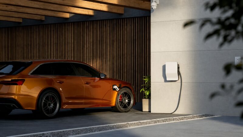 Električni automobil priključen na wallbox punjač u kućnoj garaži